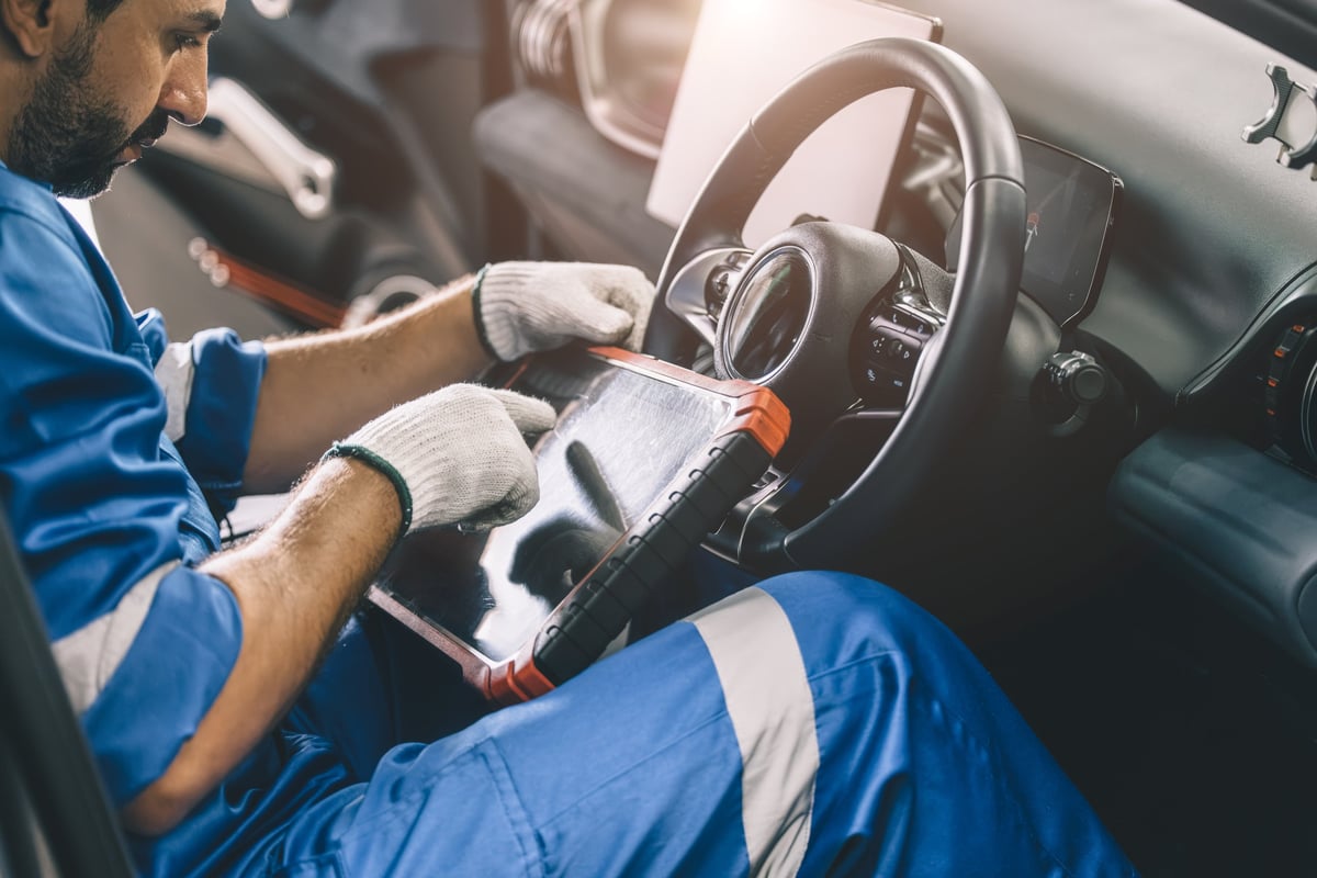John using a professional Snap-on diagnostic scanner on a BMW in a customer's driveway